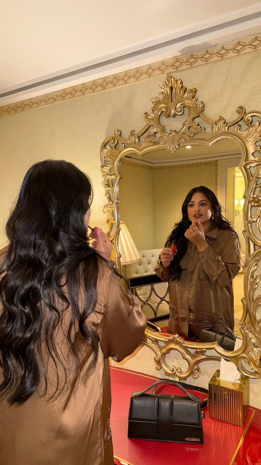 The MyShadez founder applying makeup at a mirror